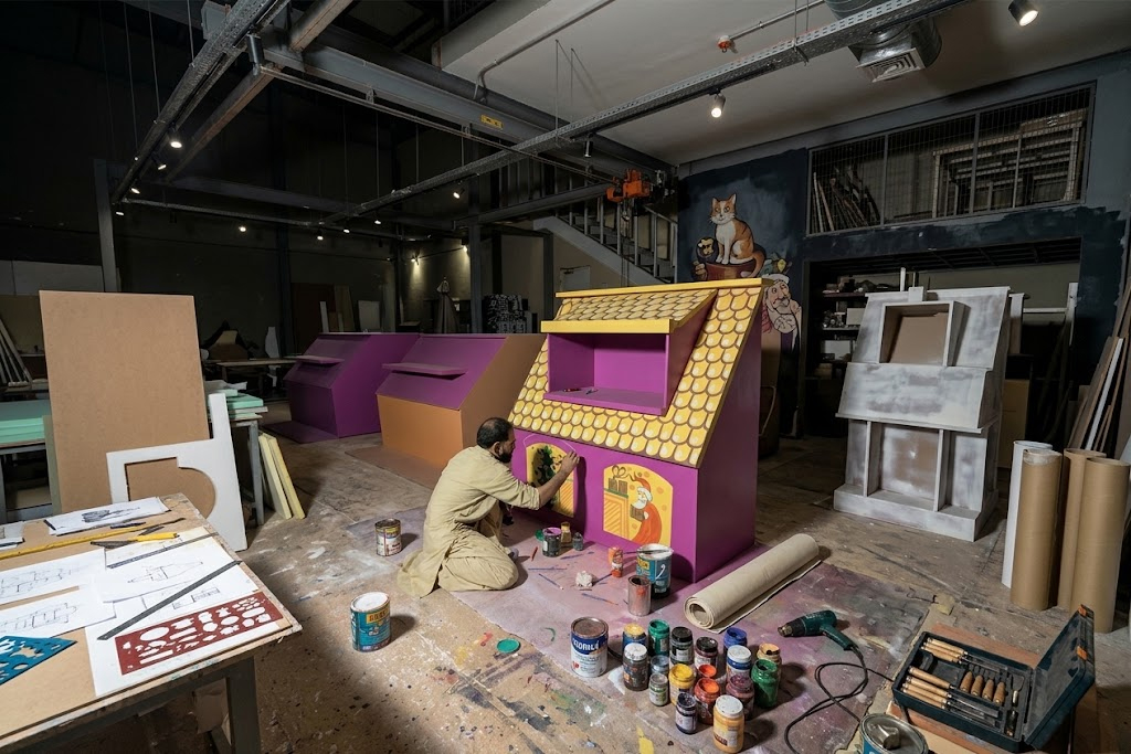 Artist hand painting a custom installation in a workshop